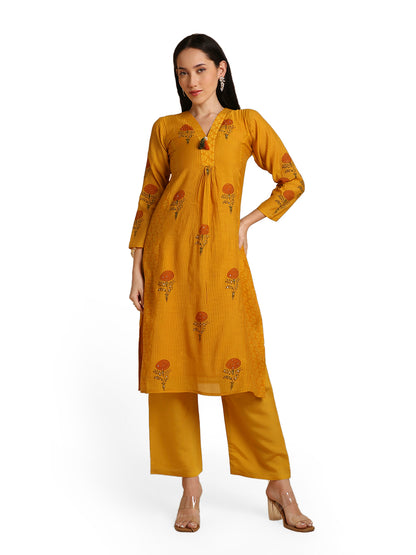 Woman wearing a mustard yellow kurta with floral patterns on a white background